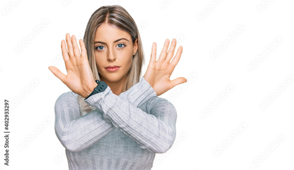 Beautiful blonde woman wearing casual clothes rejection expression crossing arms and palms doing negative sign, angry face