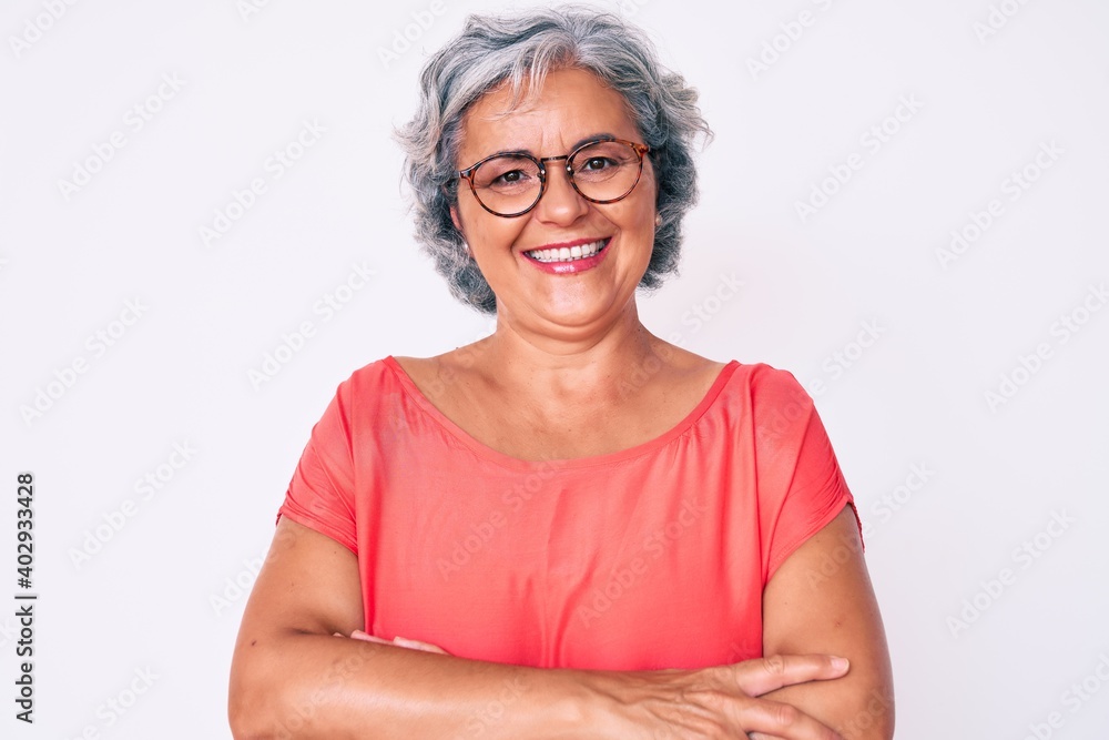 Senior hispanic grey- haired woman wearing casual clothes and glasses happy face smiling with crossed arms looking at the camera. positive person. Senior hispanic grey- haired woman wearing casual clothes and glasses happy face smiling with crossed arms looking at the camera. positive person.