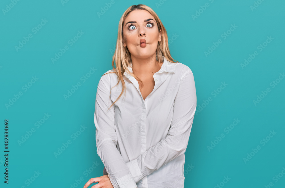 Young caucasian woman wearing casual clothes making fish face with lips, crazy and comical gesture. funny expression.