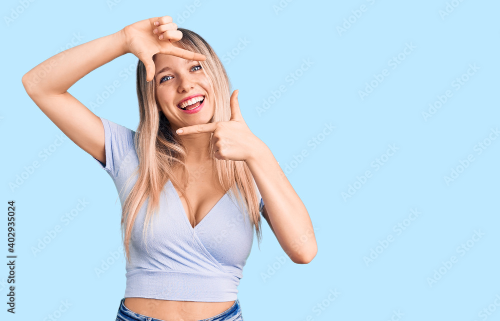 Young beautiful blonde woman wearing casual clothes smiling making frame with hands and fingers with happy face. creativity and photography concept. Young beautiful blonde woman wearing casual clothes smiling making frame with hands and fingers with happy face. creativity and photography concept.
