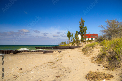 Lake Michigan Lighthouse. Waves crash on the coast of Lake Michigan with the tower of the Point Betsie Lighthouse at the horizon in the Lower Peninsula of Michigan. photo