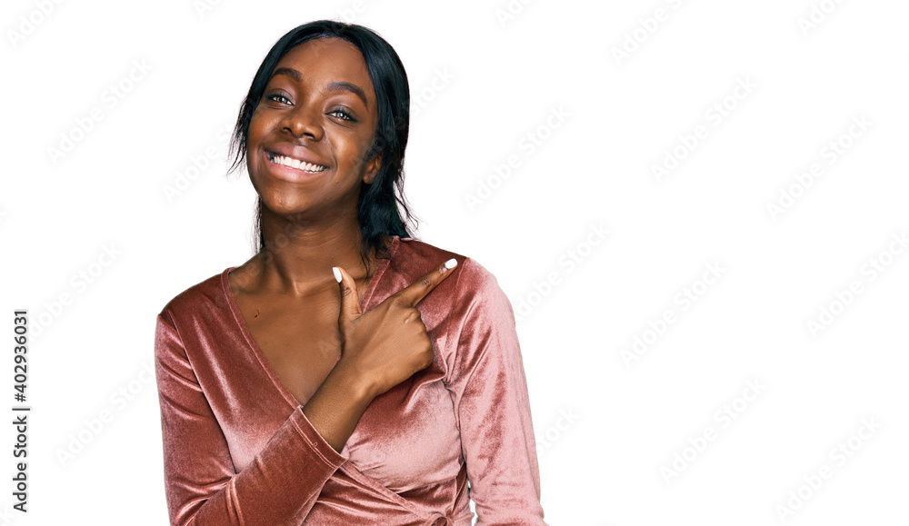 Young african american woman wearing sexy party dress cheerful with a smile of face pointing with hand and finger up to the side with happy and natural expression on face Young african american woman wearing sexy party dress cheerful with a smile of face pointing with hand and finger up to the side with happy and natural expression on face