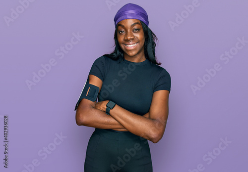 Young african american woman wearing sportswear happy face smiling with crossed arms looking at the camera. positive person.