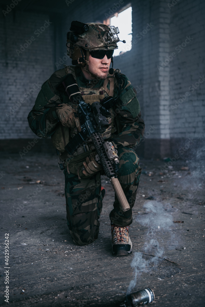 Military man armed with assault rifle running through smoke in abandoned building area Military man armed with assault rifle running through smoke in abandoned building area