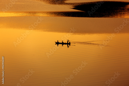 fisherman fishing from the boat on the lake at sunset © nutt