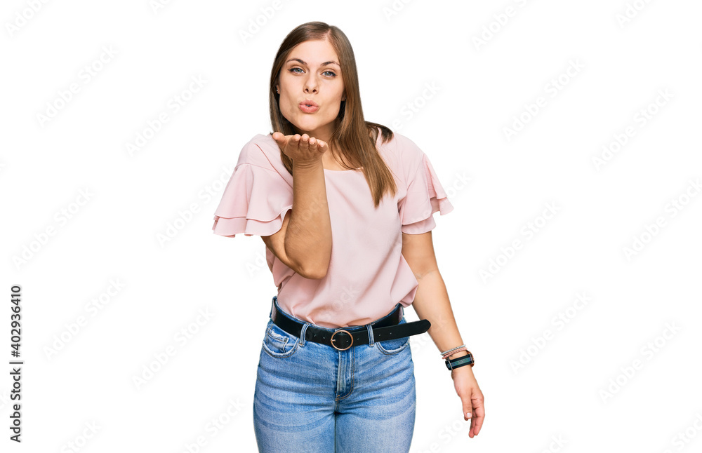 Beautiful caucasian woman wearing casual clothes looking at the camera blowing a kiss with hand on air being lovely and sexy. love expression. Beautiful caucasian woman wearing casual clothes looking at the camera blowing a kiss with hand on air being lovely and sexy. love expression.