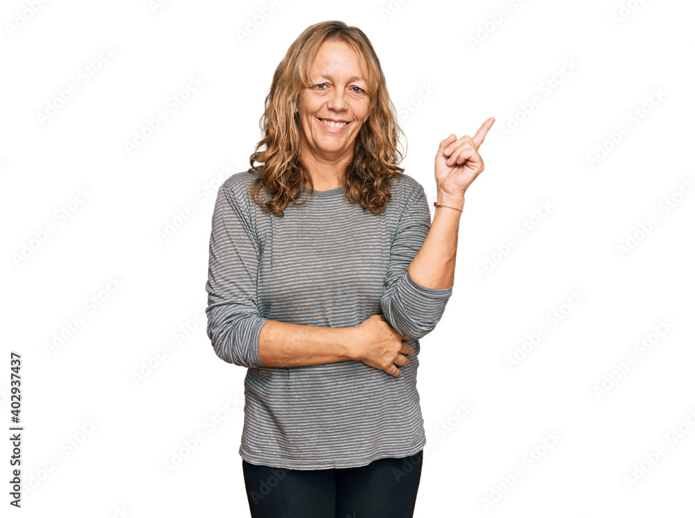 Middle age blonde woman wearing casual clothes smiling happy pointing with hand and finger to the side Middle age blonde woman wearing casual clothes smiling happy pointing with hand and finger to the side