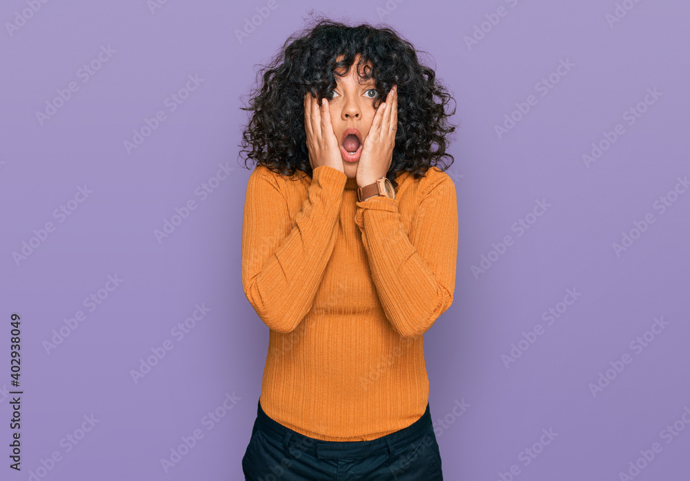 Young hispanic woman wearing casual clothes afraid and shocked, surprise and amazed expression with hands on face Young hispanic woman wearing casual clothes afraid and shocked, surprise and amazed expression with hands on face