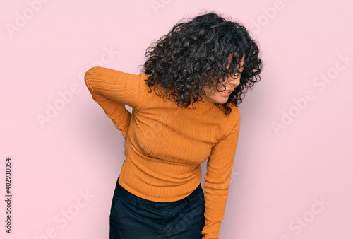 Quadro su tela Young hispanic woman wearing casual clothes suffering of backache, touching back