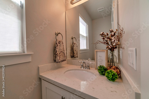 Undermount oval sink on white marble countertop with cabinet inside bathroom