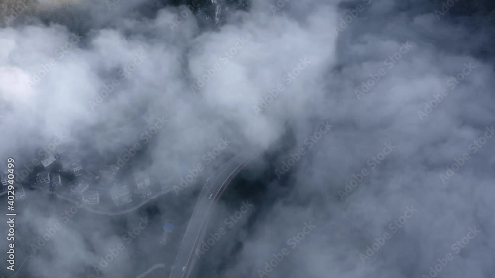 Aerial: top down view over cloudy karst mountains, remote Chinese town Aerial: top down view over cloudy karst mountains, remote Chinese town