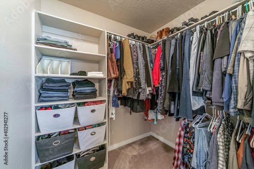 Interior of residential home walk in closet with built in open storage shelves © Jason