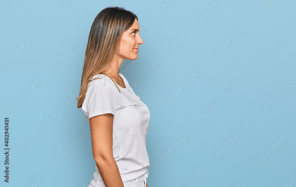 Young woman wearing casual white t shirt looking to side, relax profile pose with natural face with confident smile. Young woman wearing casual white t shirt looking to side, relax profile pose with natural face with confident smile.