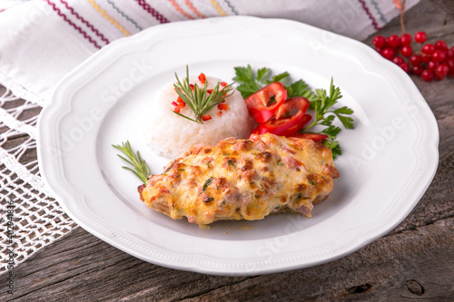 Fototapeta Naklejka Na Ścianę i Meble -  Chicken fillet baked in cheese with rice and vegetables. Balkan cuisine. National cuisine. Nourishing, useful, natural. Rustic cuisine.