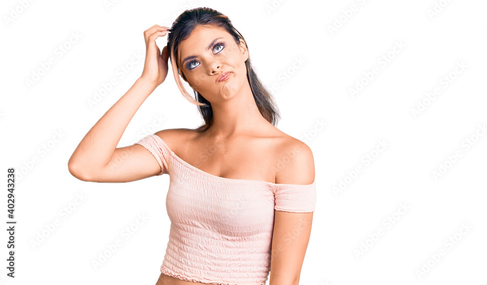 Young beautiful woman wearing casual clothes confuse and wondering about question. uncertain with doubt, thinking with hand on head. pensive concept. Young beautiful woman wearing casual clothes confuse and wondering about question. uncertain with doubt, thinking with hand on head. pensive concept.