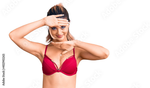 Young beautiful woman wearing bikini smiling cheerful playing peek a boo with hands showing face. surprised and exited