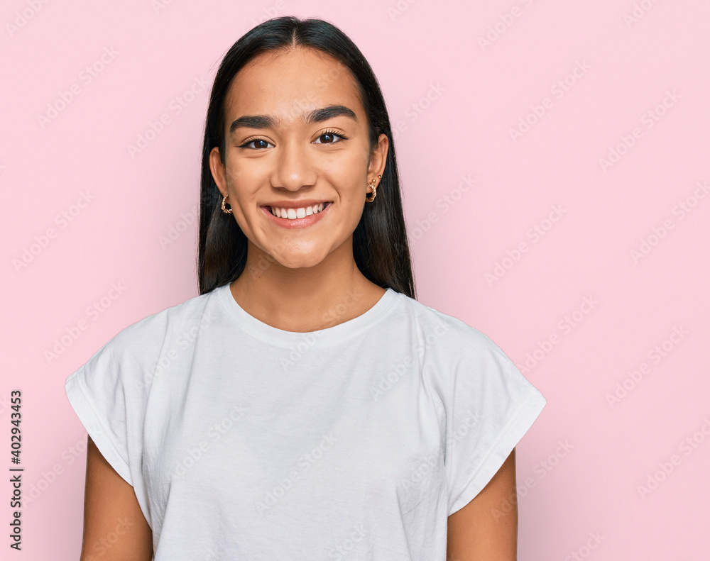Young asian woman wearing casual white t shirt with a happy and cool smile on face. lucky person.