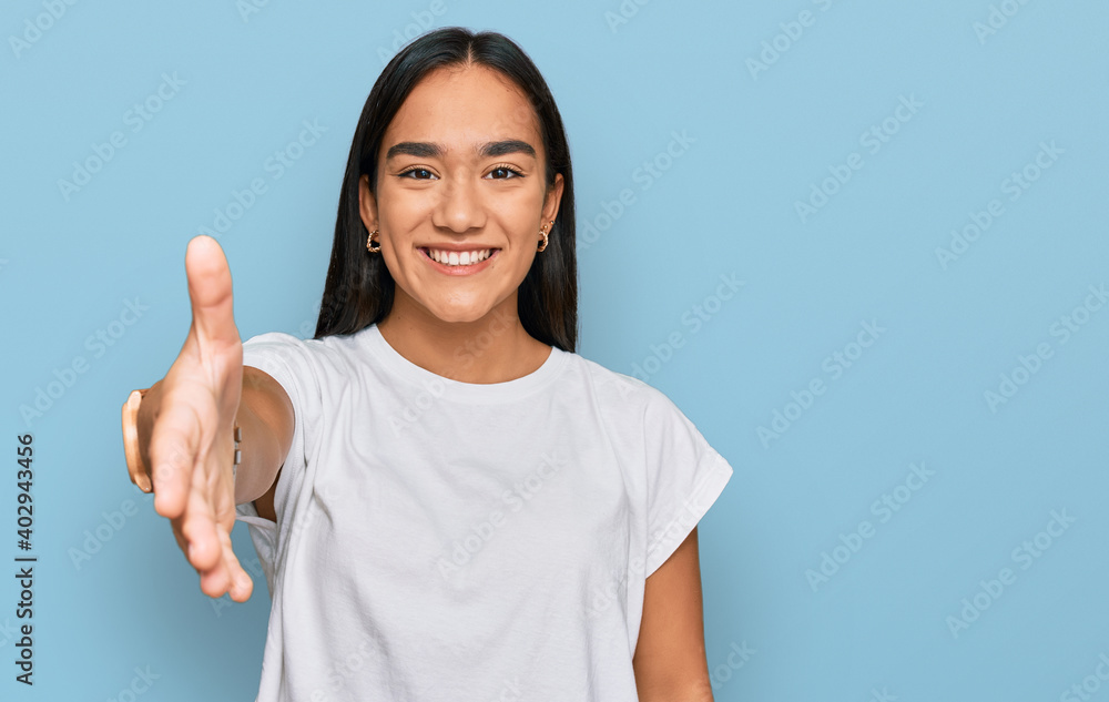 Young asian woman wearing casual white t shirt smiling friendly offering handshake as greeting and welcoming. successful business. Young asian woman wearing casual white t shirt smiling friendly offering handshake as greeting and welcoming. successful business.