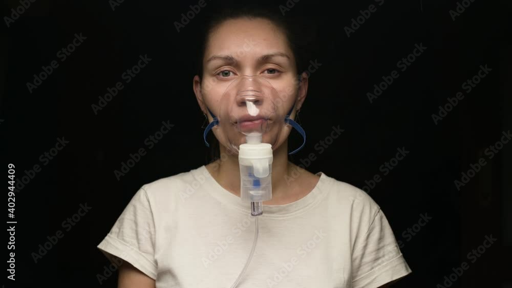 Young woman treats lungs and respiratory tract with an inhaler and special solutions Young woman treats lungs and respiratory tract with an inhaler and special solutions