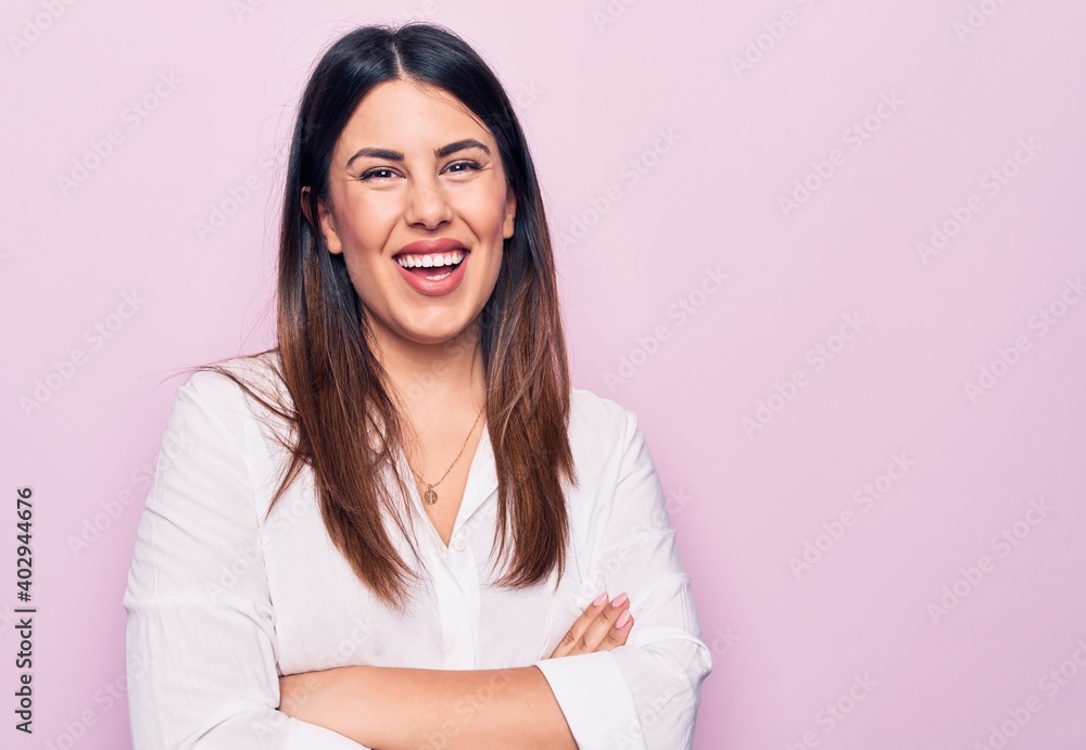 Young beautiful brunette woman wearing elegant shirt standing over isolated pink background happy face smiling with crossed arms looking at the camera. Positive person. Young beautiful brunette woman wearing elegant shirt standing over isolated pink background happy face smiling with crossed arms looking at the camera. Positive person.