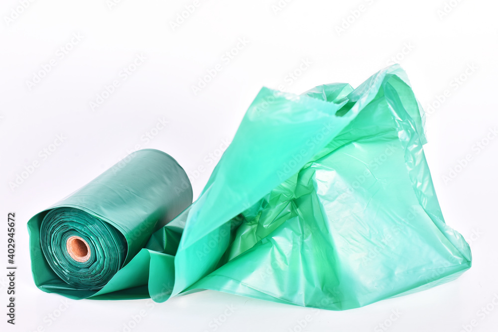 A close up image of large green dog poop bags on a white background. A close up image of large green dog poop bags on a white background.