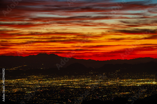 Tucson Arizona as seen from above with the colors of sunset in the distance and mountains.