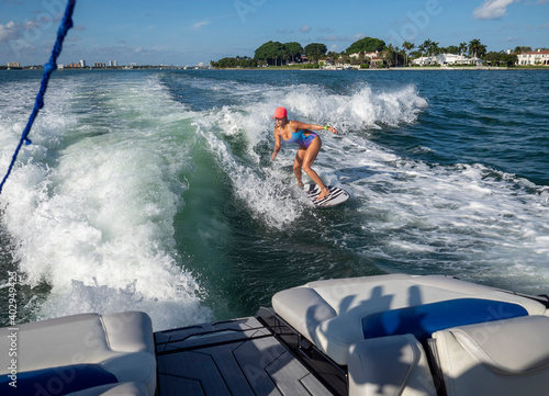 Woman wakesurfing behind boat in Florida during summer photo