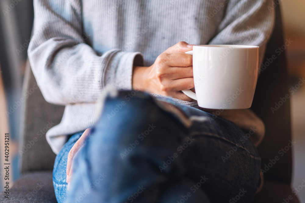 Closeup image of a woman holding a cup of coffee in cafe Closeup image of a woman holding a cup of coffee in cafe
