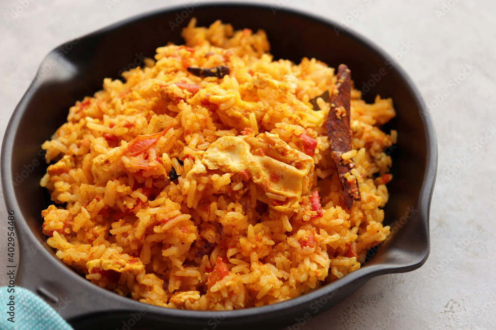 Tomato rice with eggs. Stir fried rice in spicy tomato sauce mixed with egg and spices. Served in an iron pan. Tomato rice with eggs. Stir fried rice in spicy tomato sauce mixed with egg and spices. Served in an iron pan.