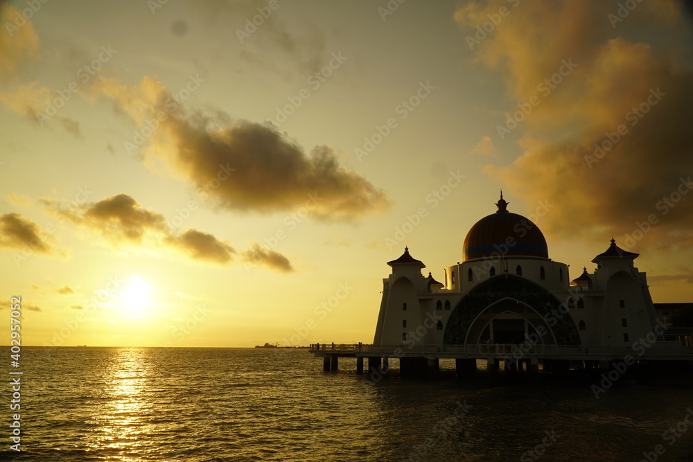 A mosque next to water and sunset