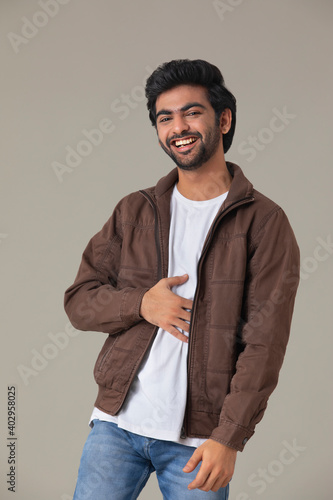 A YOUNG MAN LOOKING AT CAMERA AND LAUGHING	 photo