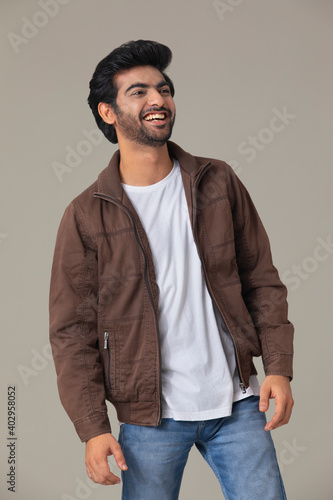 A YOUNG MAN LOOKING AT SIDE AND LAUGHING	 photo