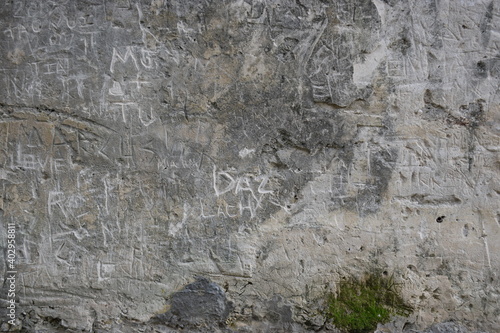 Old grey stone wall with graffiti and tagging