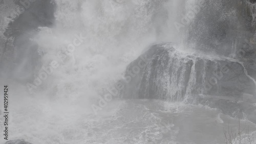 Slow Motion Crashing Water at Bottom of Foggy Icy Waterfall - Shallow DOF photo