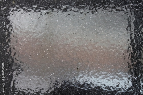Close-up of frosted car windshield. Car covered with ice. Winter frozen front window car, ice glass freeze texture background.