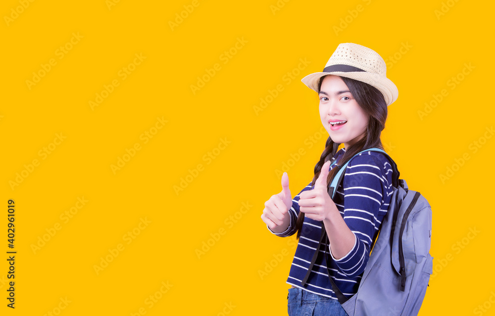 Asian woman tourist was running her to various places.happy excited emotional young woman photographer tourist standing isolated over Orange background Asian woman tourist was running her to various places.happy excited emotional young woman photographer tourist standing isolated over Orange background