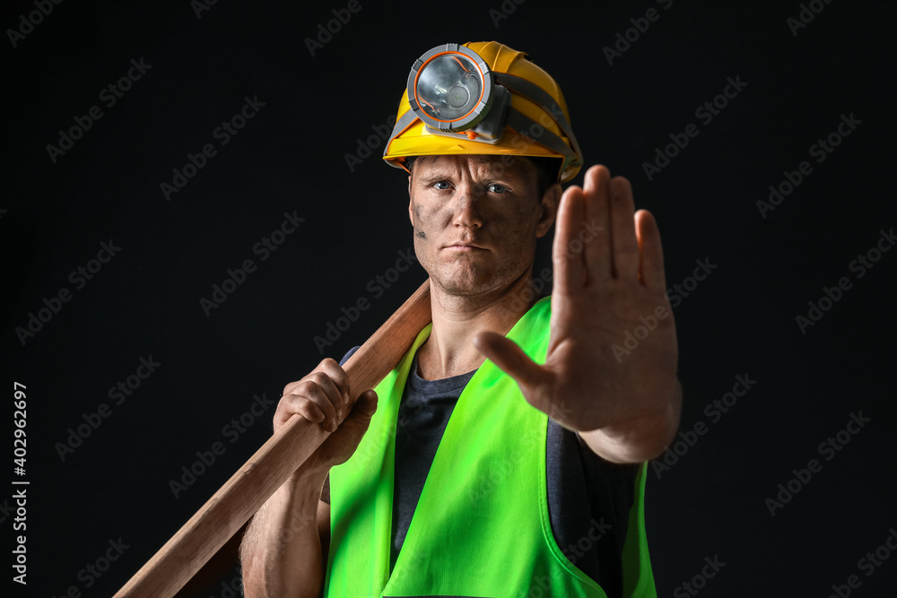 Miner man showing STOP gesture on dark background Miner man showing STOP gesture on dark background