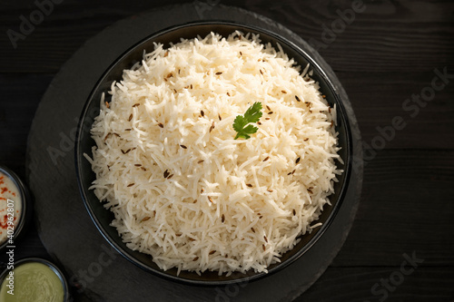 Bild auf Leinwand Steamed rice with Cumin  in a black bowl with green chutney and curd