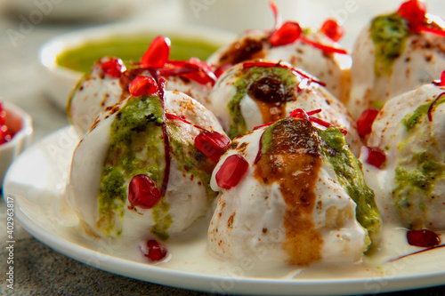 Dahi Vada or Dahi Bhalle a popular Indian snack is fried lentil dumplings, topped with curd, sweet and green chutney and spices	 photo