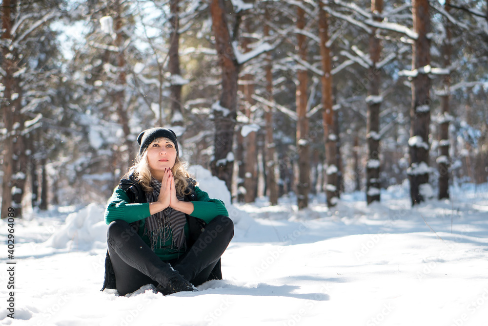Young woman meditates in snowy forest or park. Young woman meditates in snowy forest or park.