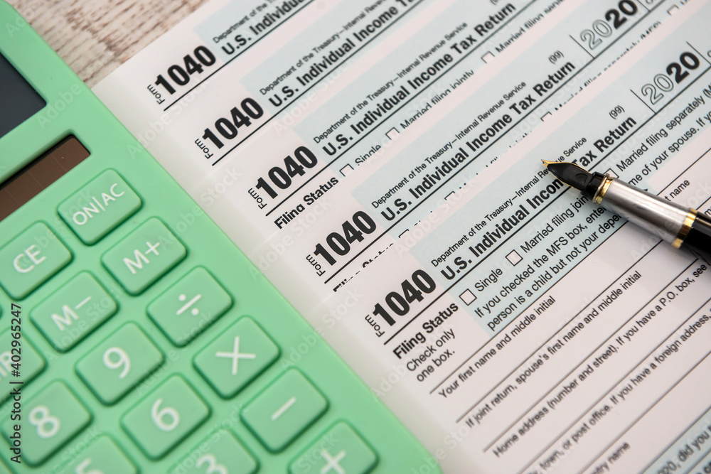 paperwork 1040 individual income tax form document with pen and calculator paperwork 1040 individual income tax form document with pen and calculator
