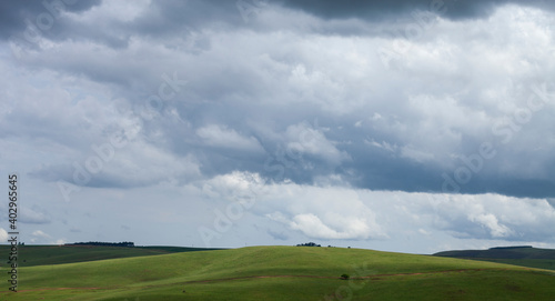 Rolling green hills landscape with a big, dramatic sky