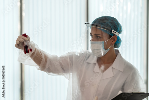 Female doctor holding sample for analysis  of Covid-19 infectious disea photo