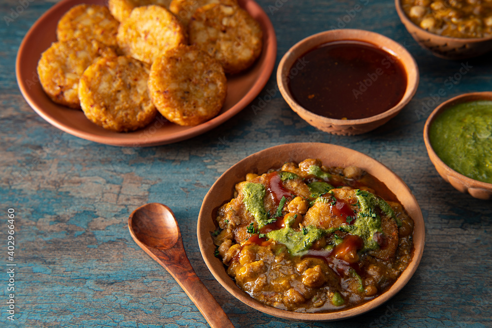 PINDI CHOLE CURRY SERVED WITH ALOO TIKKI AND CHUTNEY PINDI CHOLE CURRY SERVED WITH ALOO TIKKI AND CHUTNEY