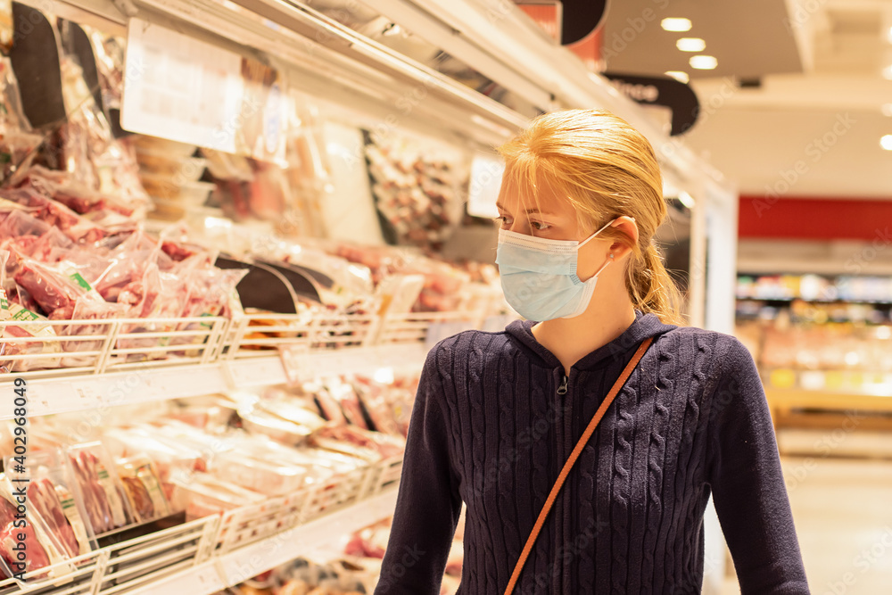 Wearing face masks in shopping centres are compulsory in Greater Sydney NSW. A girl wearing disposable face mask at the supermarket. Covid-19 restrictions