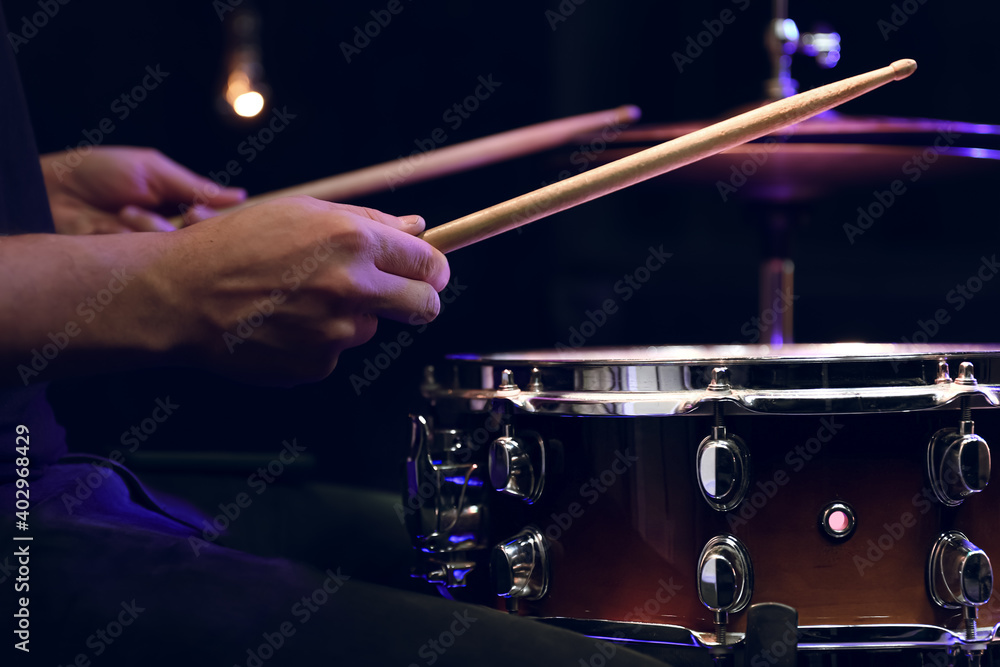 Naklejka premium Drummer playing snare drum with sticks close up.