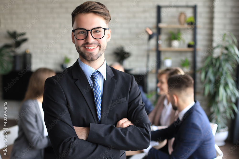 Businessman with colleagues in the background in office.