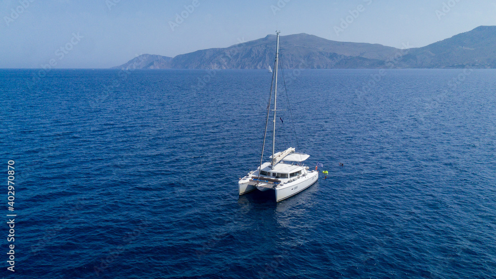 Fototapeta premium Catamaran sailing in blue, turquoise water in Greece, beautiful catamaran during summer holiday, view from drone