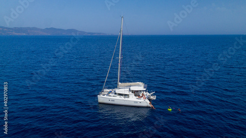 Fotografiet Catamaran sailing in blue, turquoise water in Greece, beautiful catamaran during