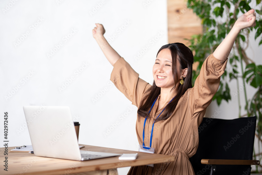 オフィスでバンザイするビジネスウーマン
